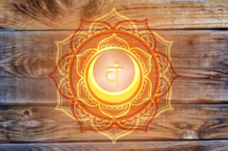 Mandala orange du chakra sacré Svadhisthana sur un fond de bois